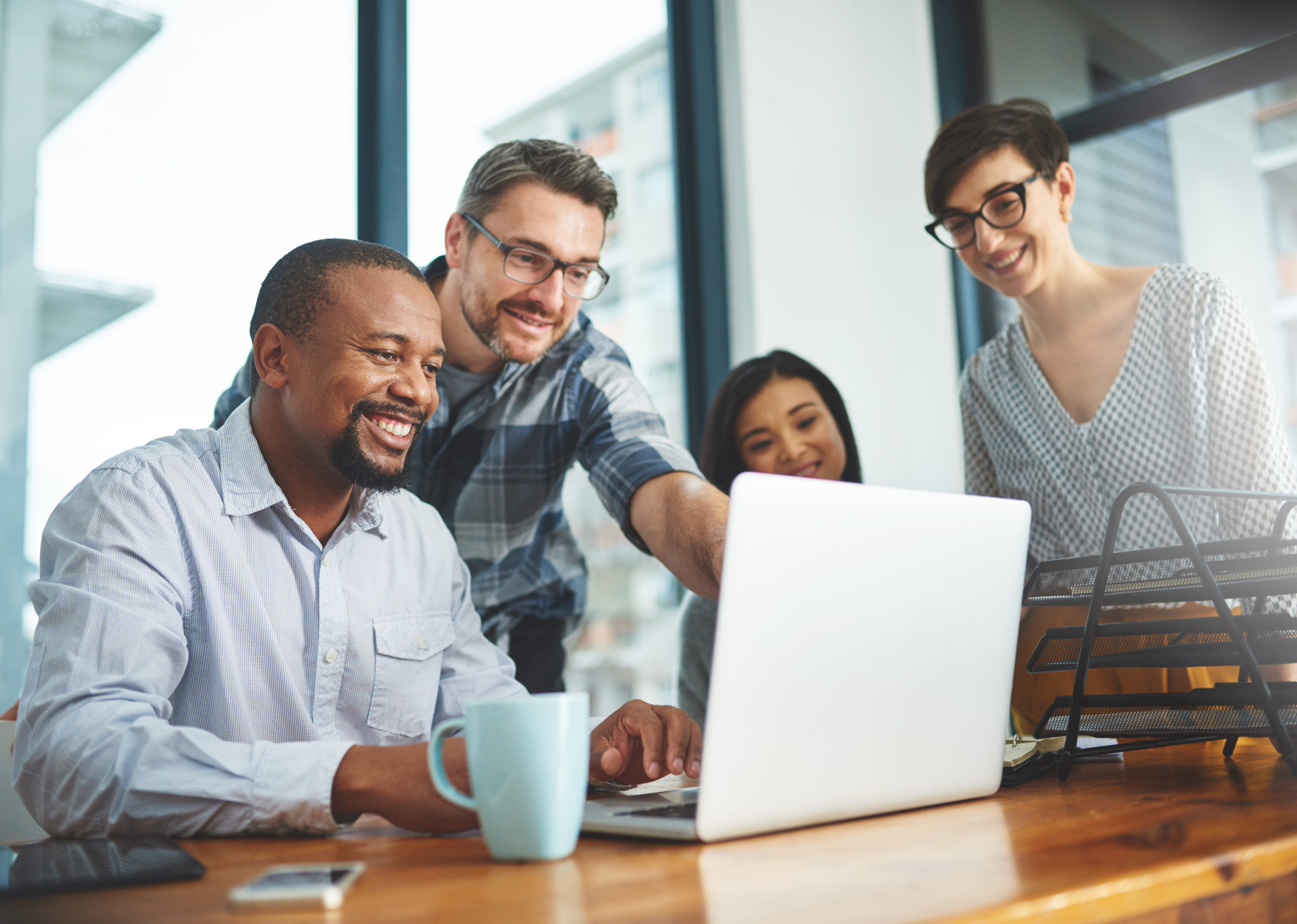 Team of colleagues collaborating at a laptop