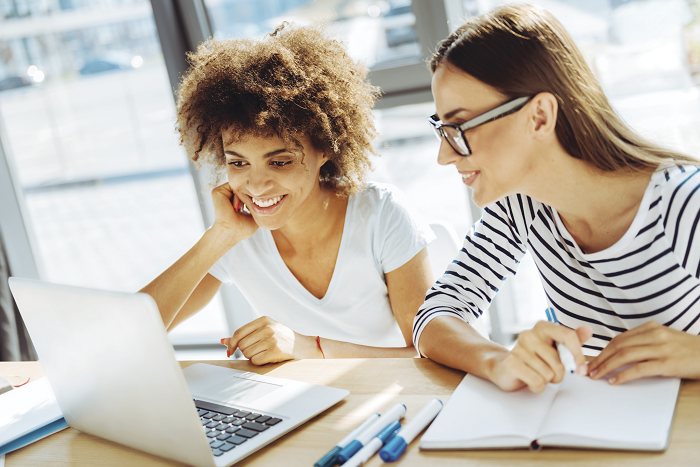 Two women looking at a computer screen together