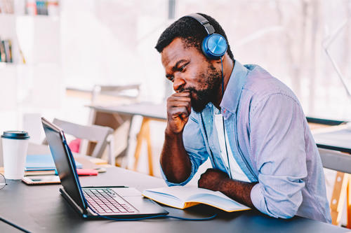 Man with headphones studying for CMA exam