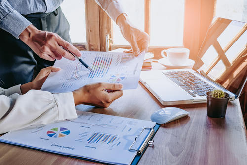 Business team analyzing income charts and graphs with modern laptop computer.