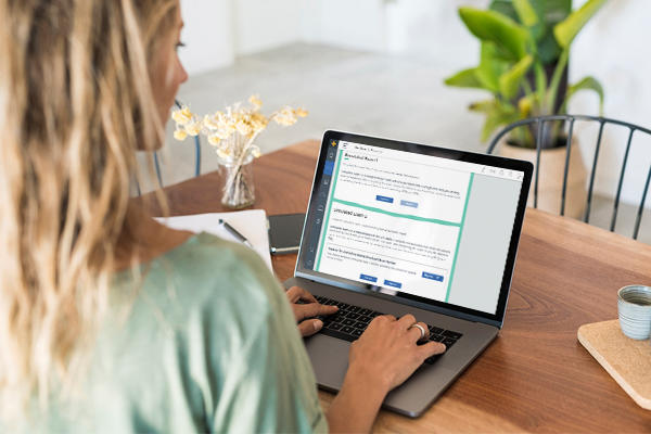 A woman typing something into a laptop.