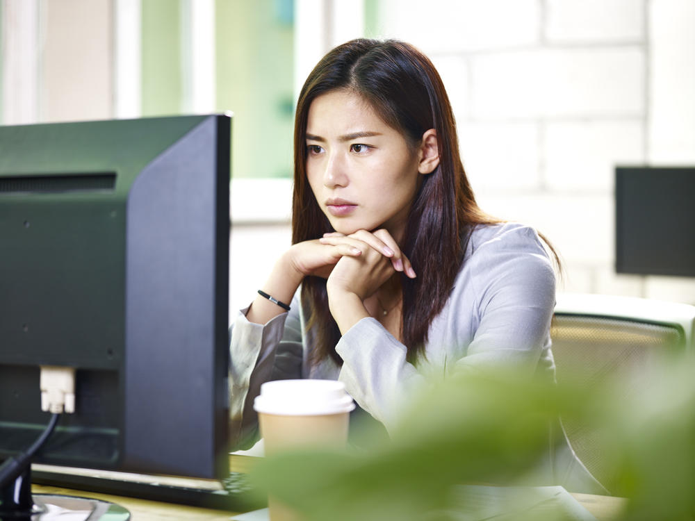Young Asian businesswoman working in office using computer.