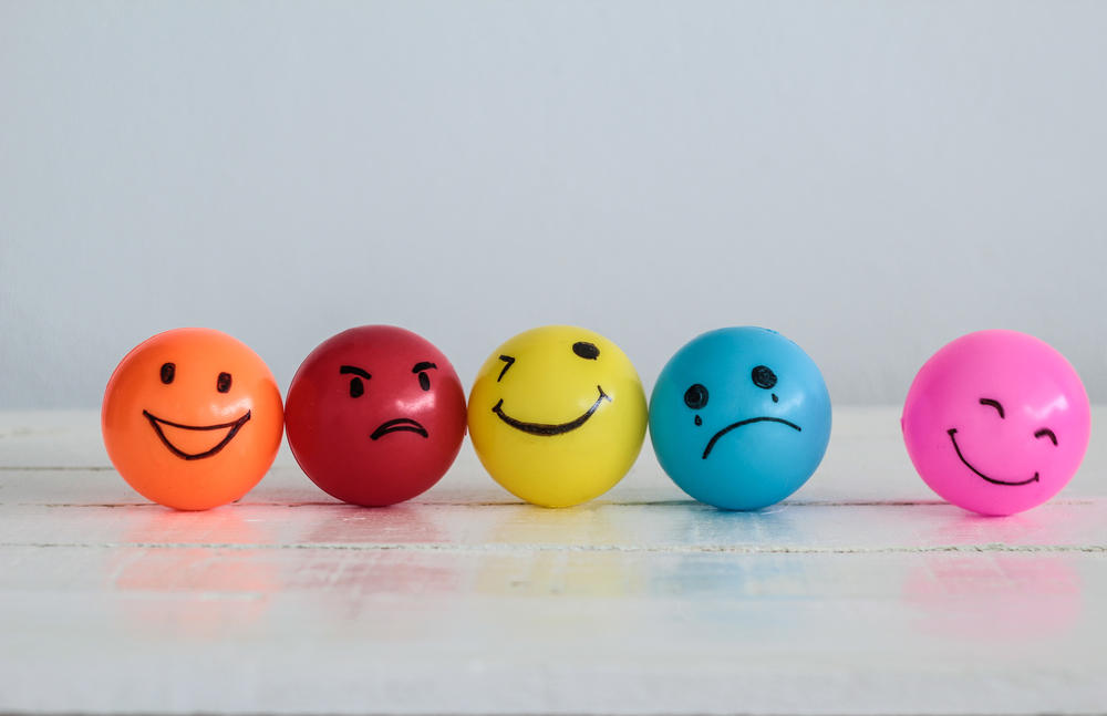 Emotions balls background, Happy Smiley faces ball in yellow , orange and pink. Sadness ball in blue and madness ball in red. Self made hand draw balls.