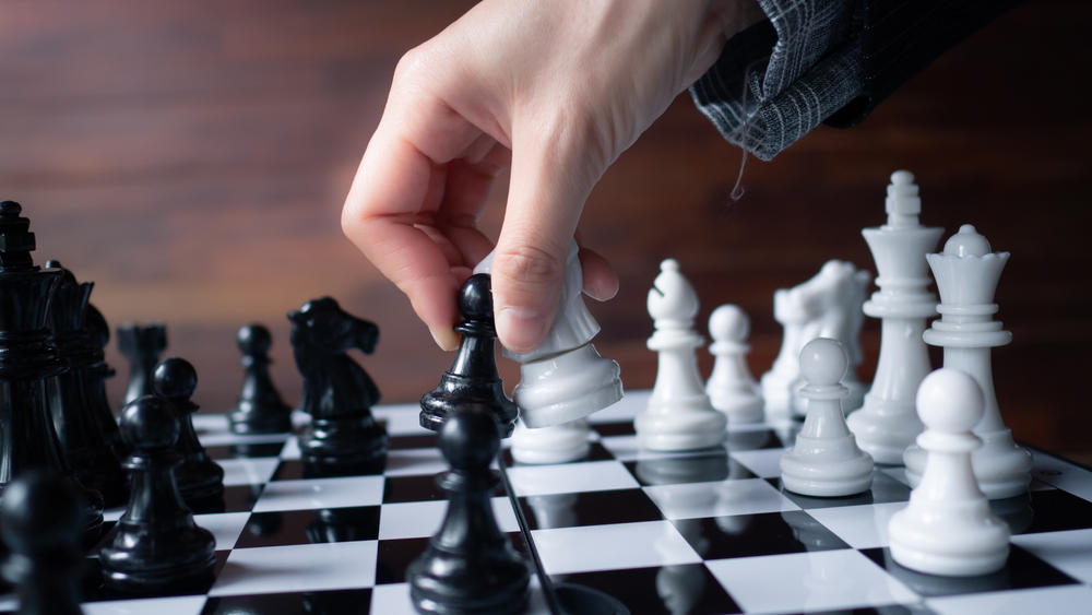Hand of player chess, illustrate business person planing. Business strategy for winning and success. Selective focus