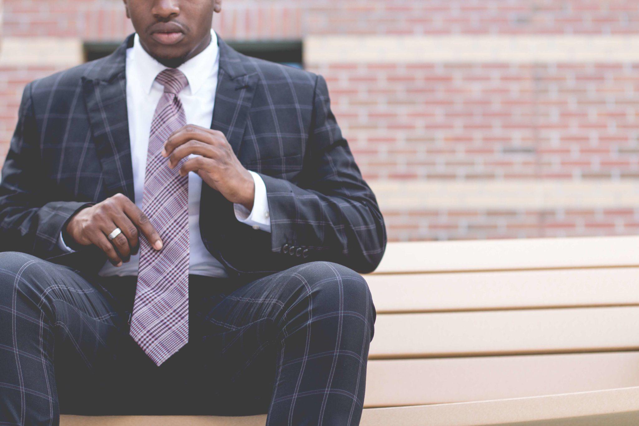 man in business professional adjusts tie