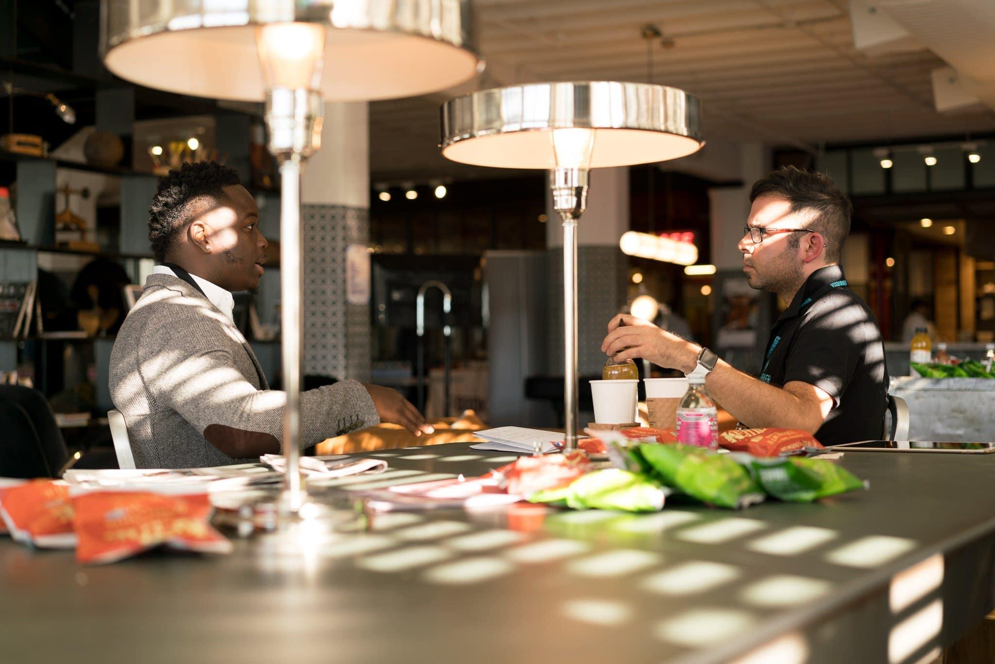 two men talking at a table