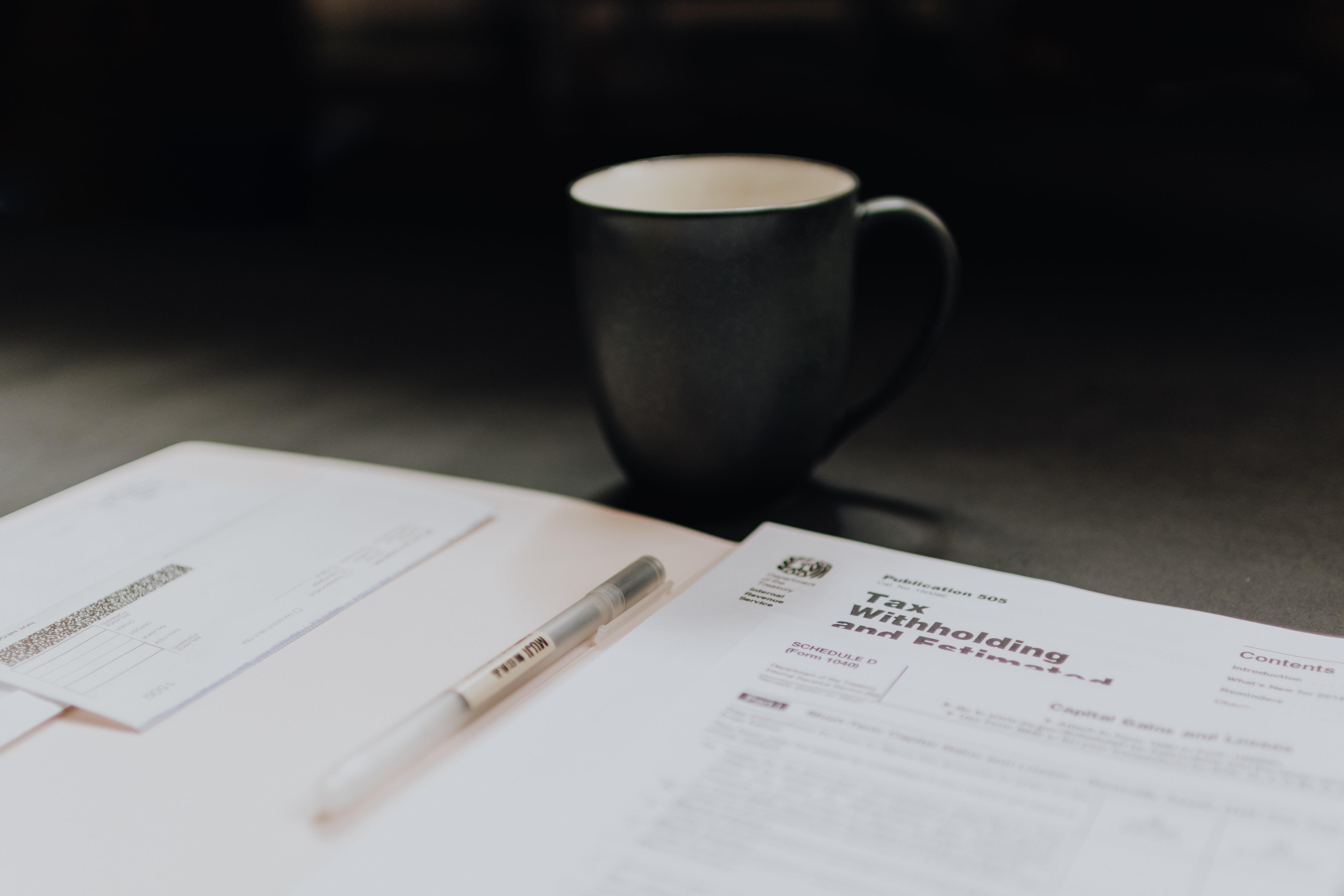 coffee mug next to folder with tax documents