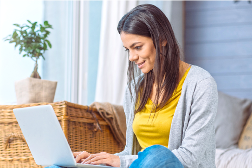 Becker woman working on laptop in front a potted plant