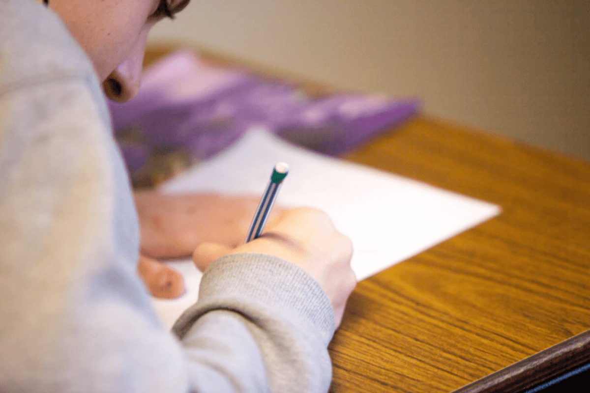 Person writing at desk