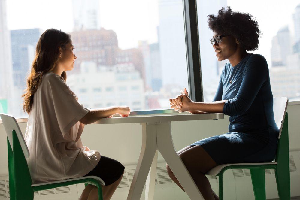 two women interviewing at a table