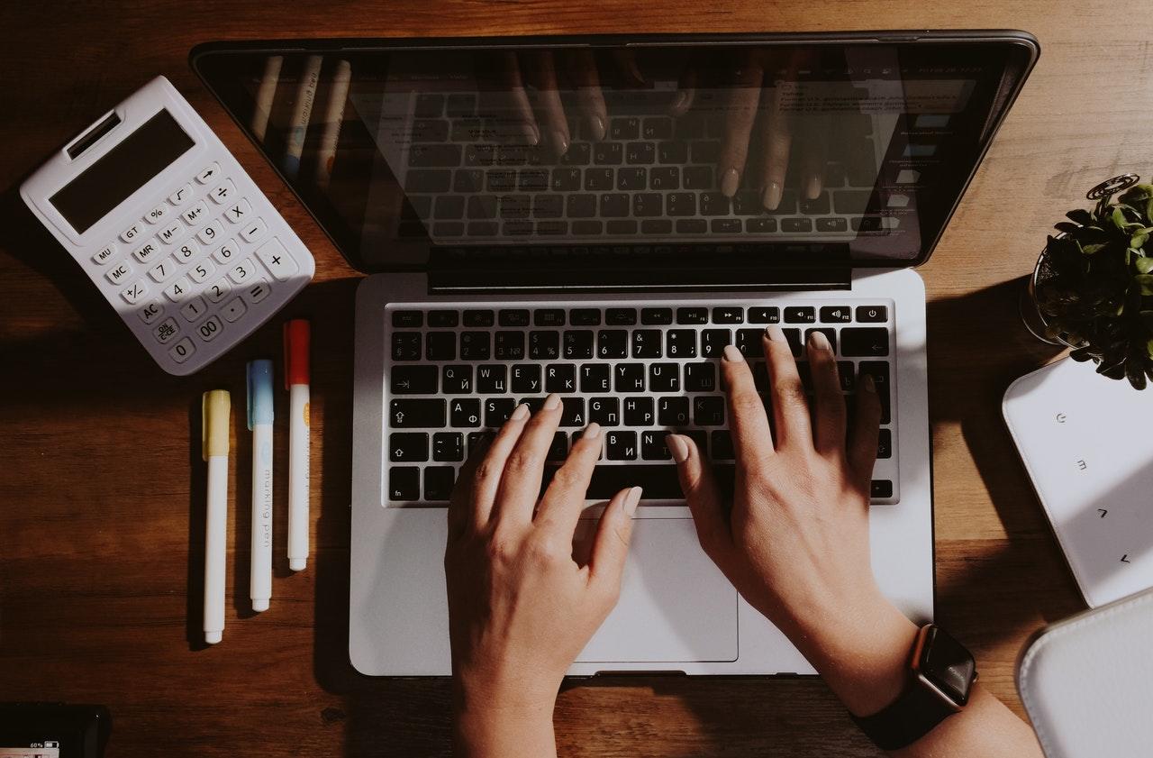 Laptop with highlighters and a calculator on the side