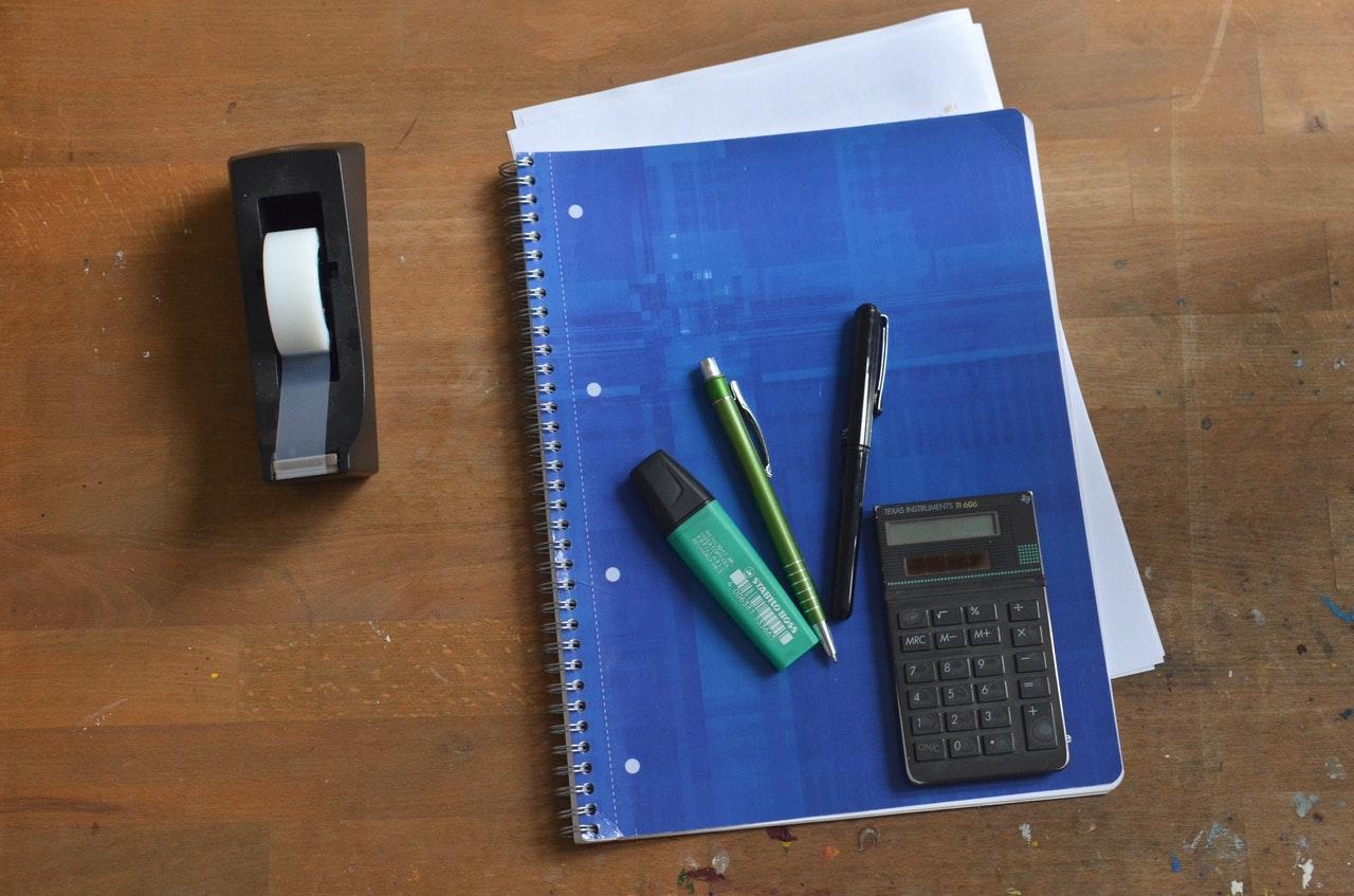 Notebook with pencils and calculator on top