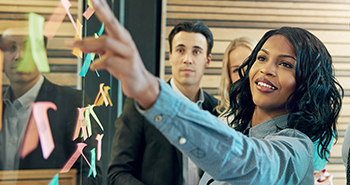 A diverse team looking at a meeting board