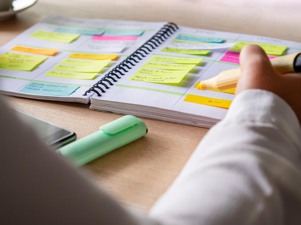 person taking notes in a calendar planner