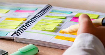 Student highlighting a calendar with post-it notes 
