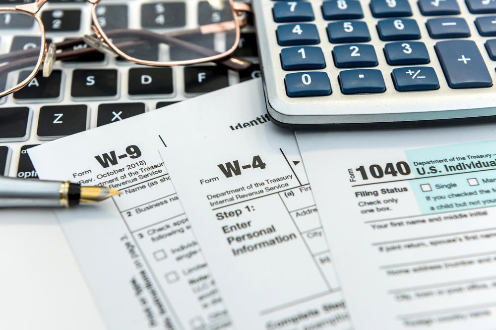 tax documents and a calculator on a desk