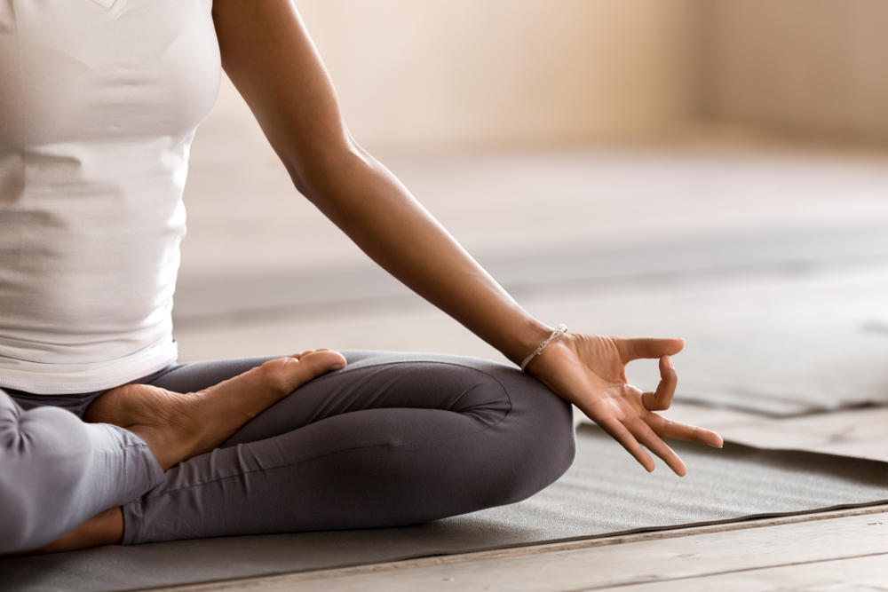person meditating on yoga mat