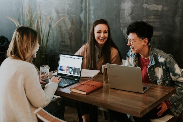 college students meeting and working on laptops