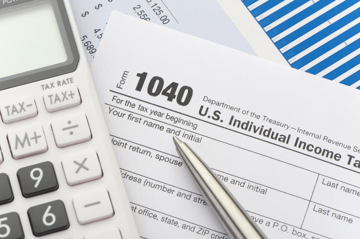 tax form 1040 next to a pen and calculator