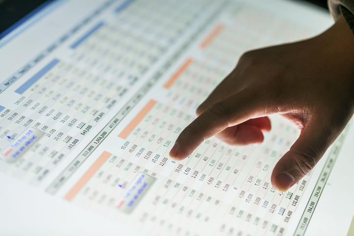 person pointing to a spreadsheet
