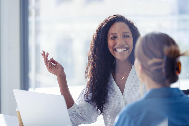 person smiling and talking in a business meeting