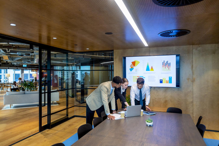three colleagues huddling in a conference room