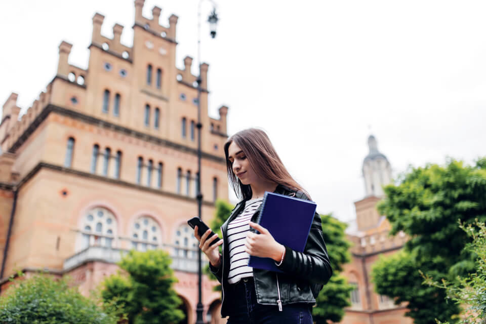 Student on campus outside looking at phone