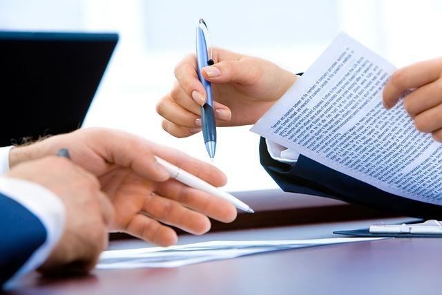 What can a cpa do that an accountant can't? Image of two peoples' hands holding documents