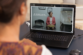 a person observing someone on a laptop