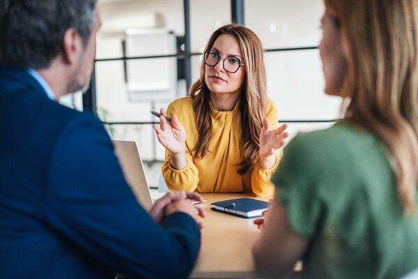 early 30s woman with glasses meeting with clients to offer tax resolution services