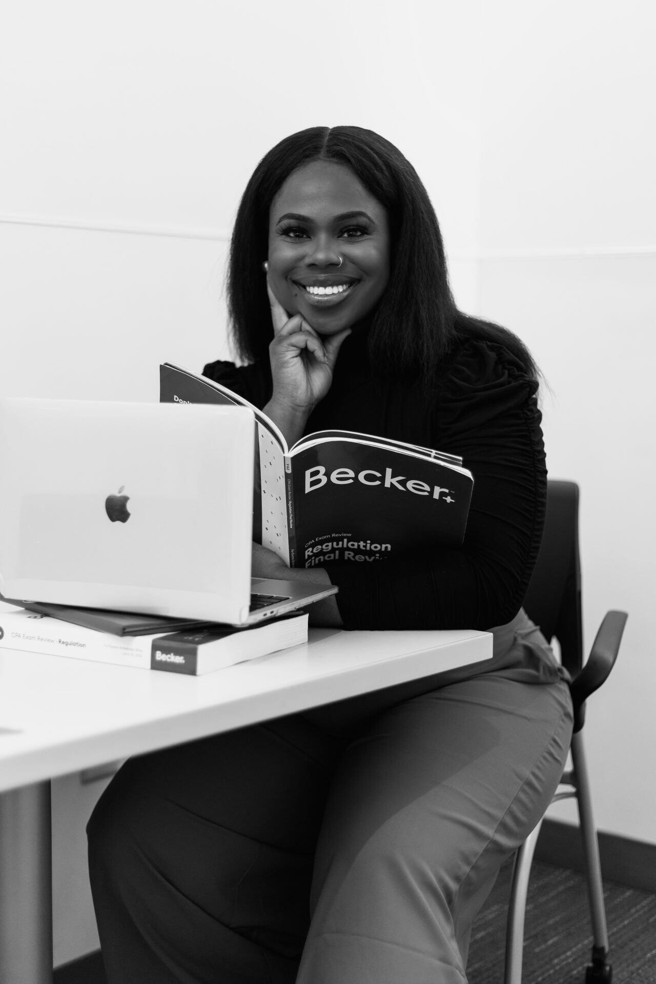 Young woman studying for CPA Exam with Becker textbook