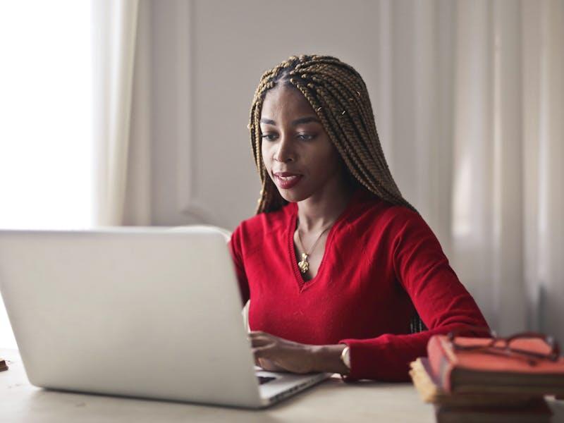 Woman working at laptop and reading Becker's CPA Exam Review Updates