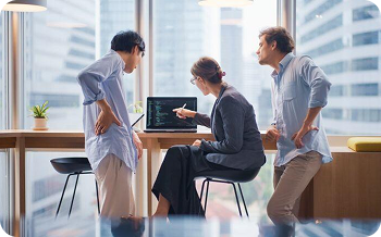 3 people around a laptop