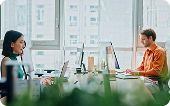 2 people working at their desks